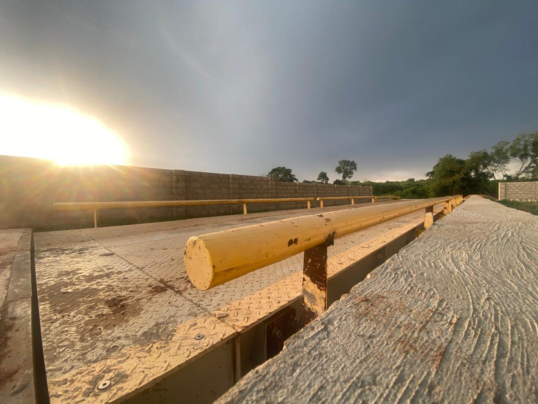 Close view along the steel deck plate and guide rail of the weighbridge platform at sunrise.